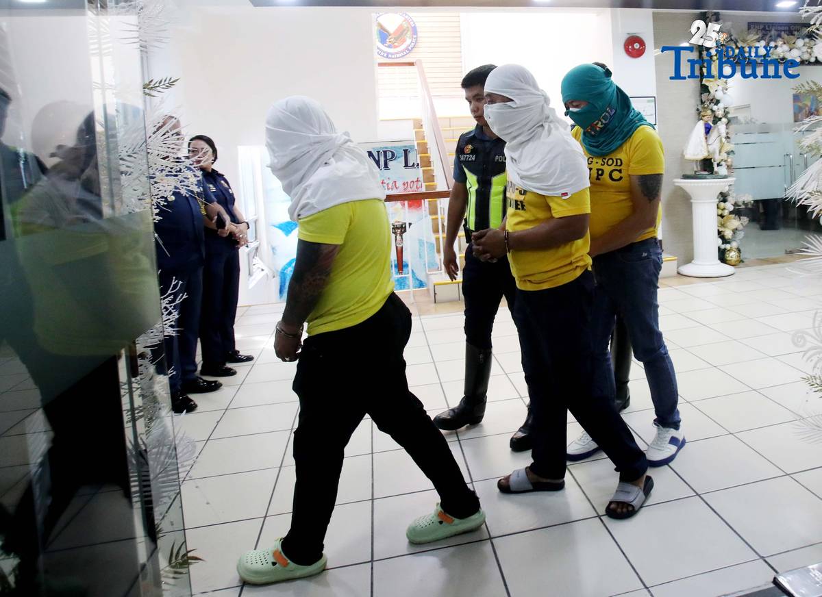 Three of the six suspects arrested in connection with the seizure of undocumented and smuggled cigarettes worth an estimated P143 million are escorted by members of the Philippine National Police–Highway Patrol Group at Camp Crame in Quezon City on Friday.