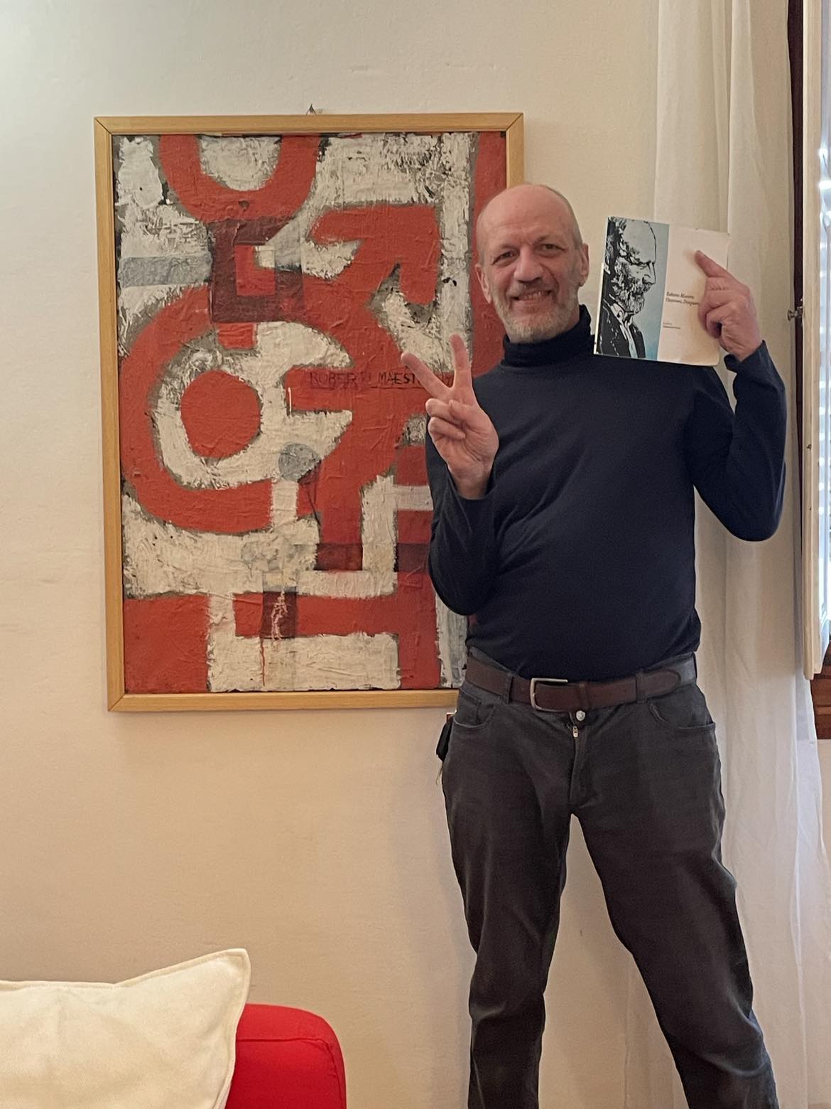 THEhouse owner, Chiro, with a painting and book by his father, Roberto Maestro.