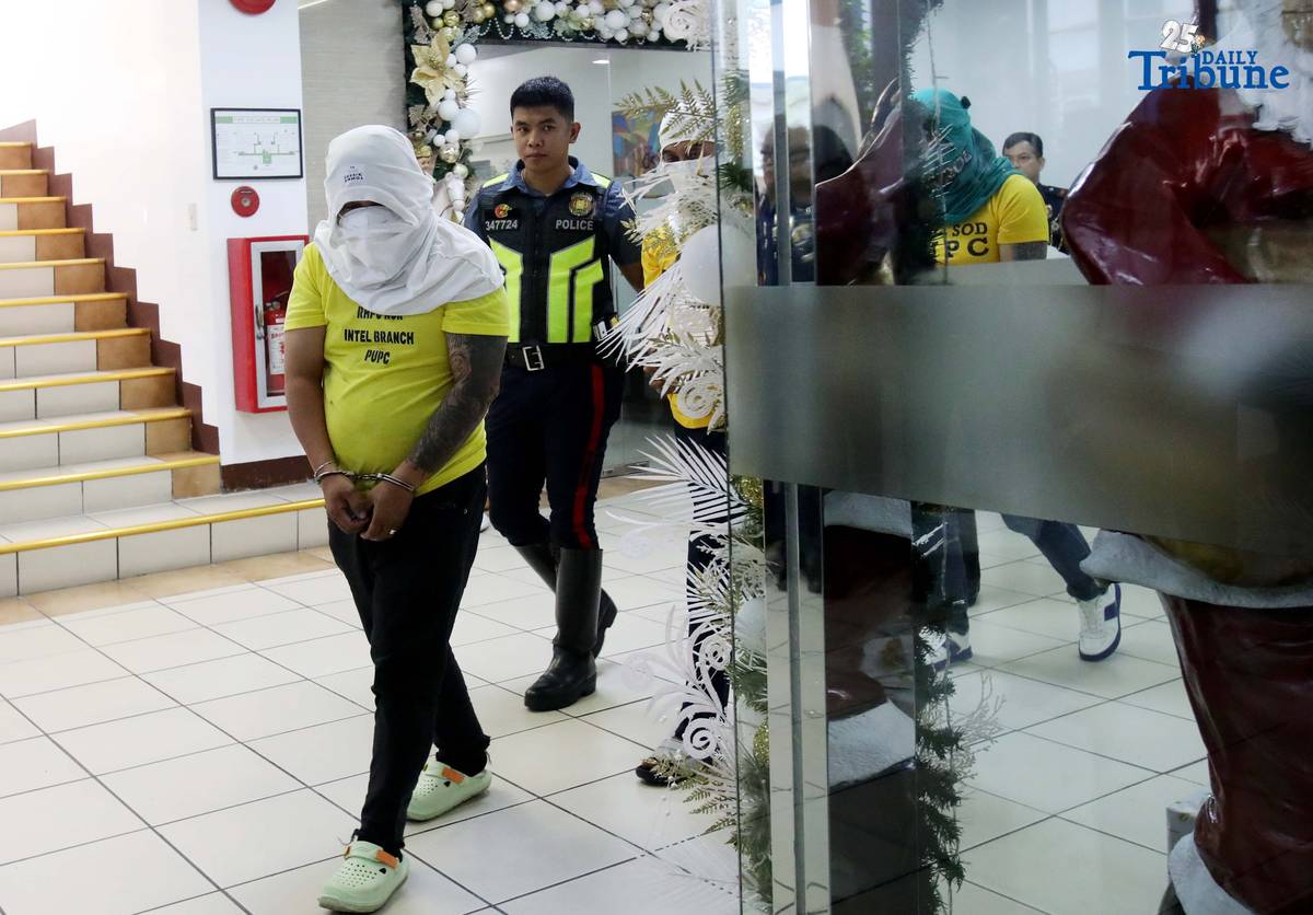 Three of the six suspects arrested in connection with the seizure of undocumented and smuggled cigarettes worth an estimated P143 million are escorted by members of the Philippine National Police–Highway Patrol Group at Camp Crame in Quezon City on Friday.