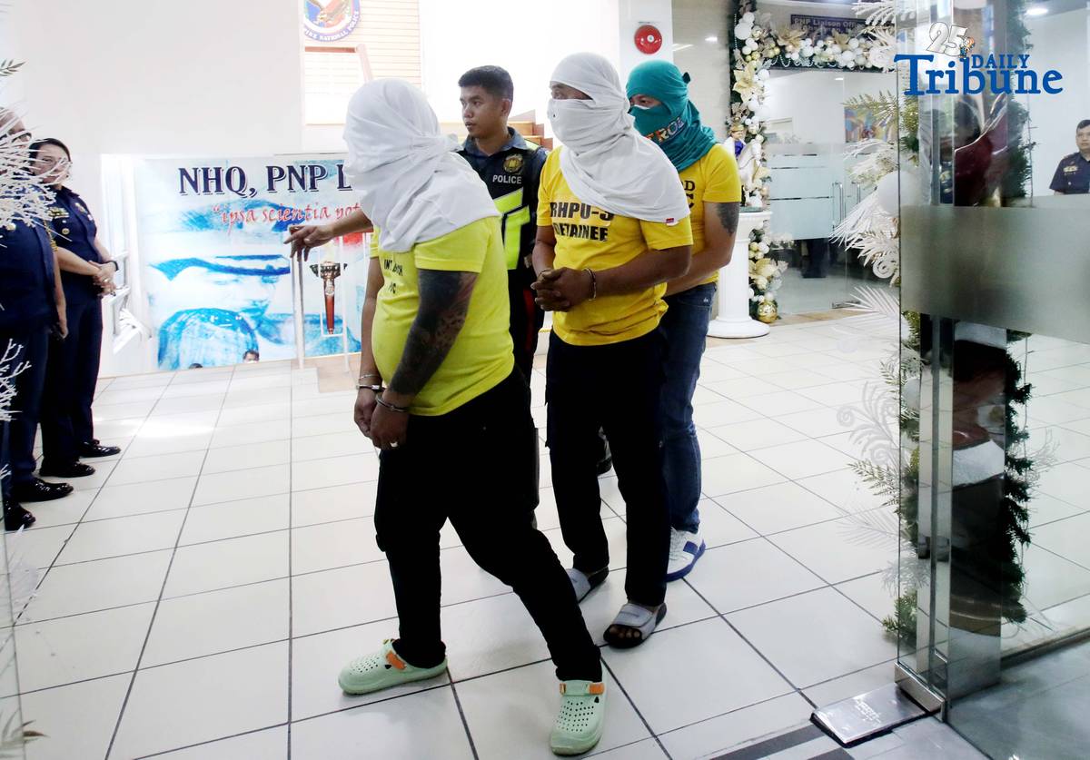 Three of the six suspects arrested in connection with the seizure of undocumented and smuggled cigarettes worth an estimated P143 million are escorted by members of the Philippine National Police–Highway Patrol Group at Camp Crame in Quezon City on Friday.