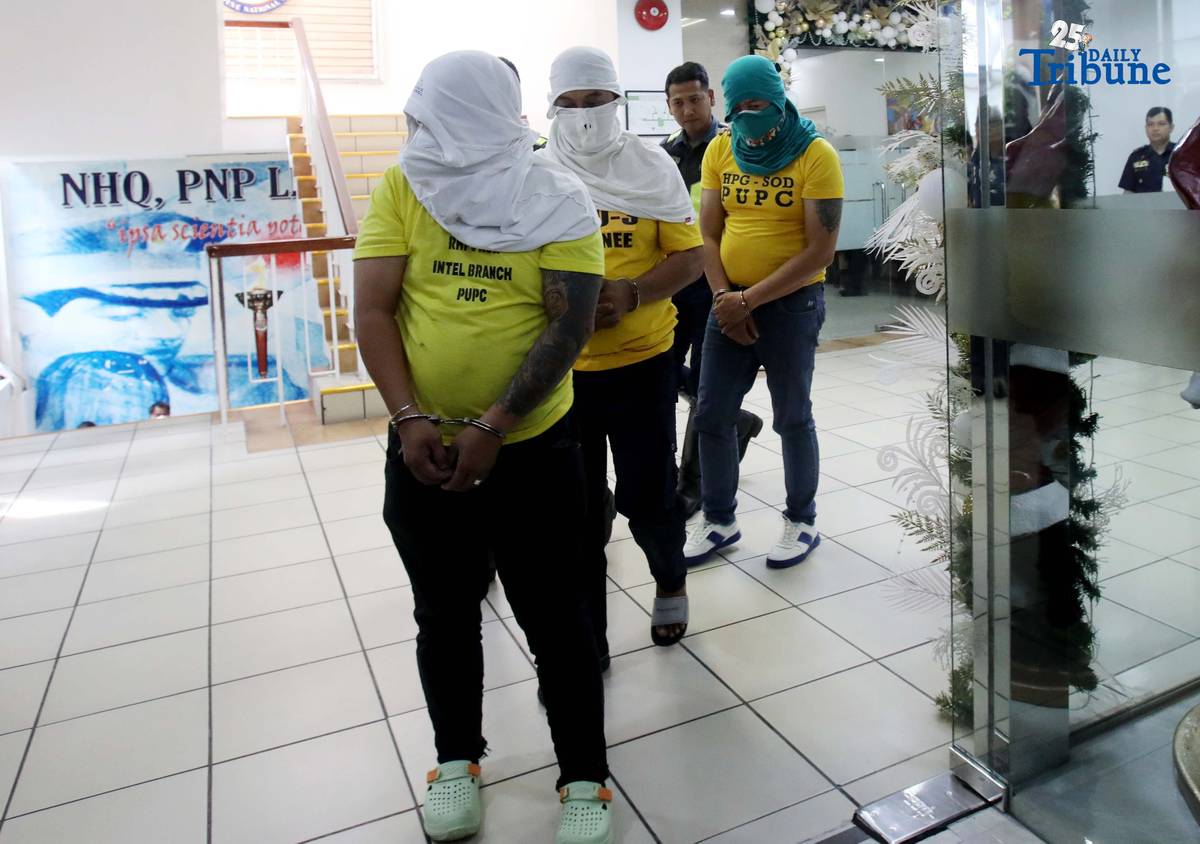 Three of the six suspects arrested in connection with the seizure of undocumented and smuggled cigarettes worth an estimated P143 million are escorted by members of the Philippine National Police–Highway Patrol Group at Camp Crame in Quezon City on Friday.