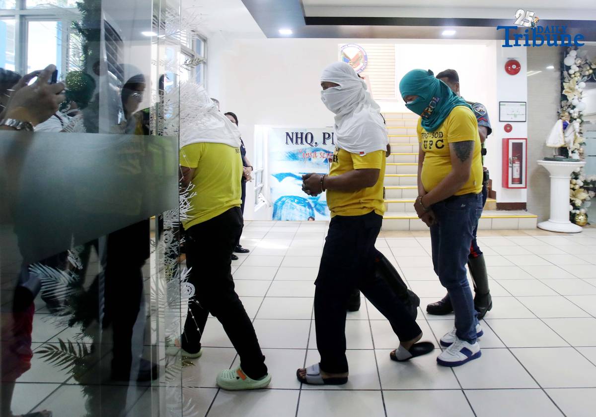Three of the six suspects arrested in connection with the seizure of undocumented and smuggled cigarettes worth an estimated P143 million are escorted by members of the Philippine National Police–Highway Patrol Group at Camp Crame in Quezon City on Friday.
