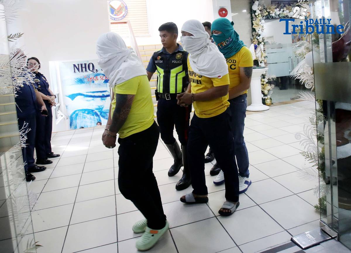 Three of the six suspects arrested in connection with the seizure of undocumented and smuggled cigarettes worth an estimated P143 million are escorted by members of the Philippine National Police–Highway Patrol Group at Camp Crame in Quezon City on Friday.