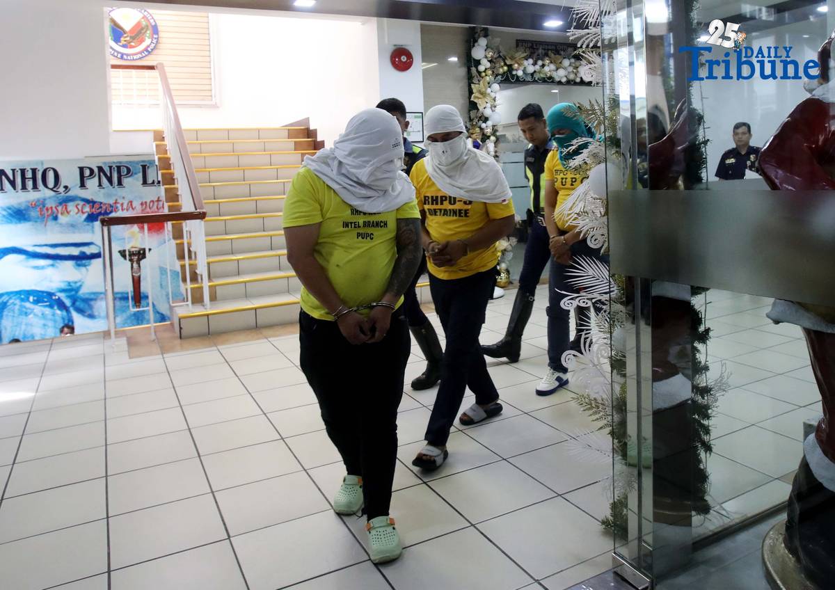 Three of the six suspects arrested in connection with the seizure of undocumented and smuggled cigarettes worth an estimated P143 million are escorted by members of the Philippine National Police–Highway Patrol Group at Camp Crame in Quezon City on Friday.