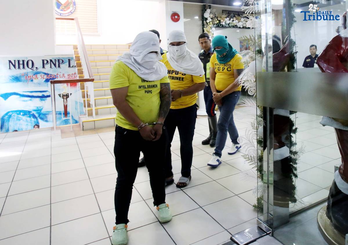 Three of the six suspects arrested in connection with the seizure of undocumented and smuggled cigarettes worth an estimated P143 million are escorted by members of the Philippine National Police–Highway Patrol Group at Camp Crame in Quezon City on Friday.