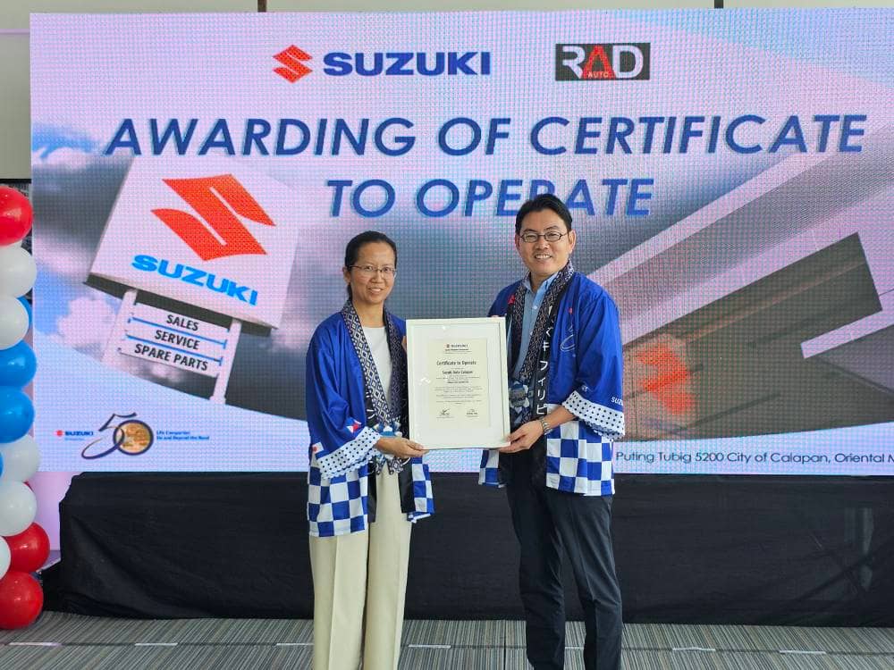 SUZUKI Philippines and Reliance Auto Dynamics present the certificate to operate for Suzuki Auto Calapan. Shown are Kristine Uy (left), Reliance Auto Dynamics president and Norihide Takei, Suzuki Philippines automobile division director and general manager.