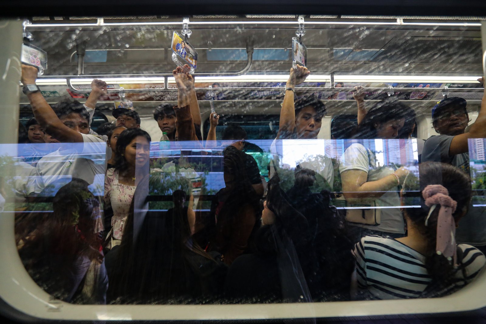 Commuters board an LRT-1 train at Doroteo Jose Station in Manila on Sunday afternoon, December 21, as the Department of Transportation rolls out its “12 Days of Christmas” free-ride program, allowing entire families to ride for free regardless of the number of members.