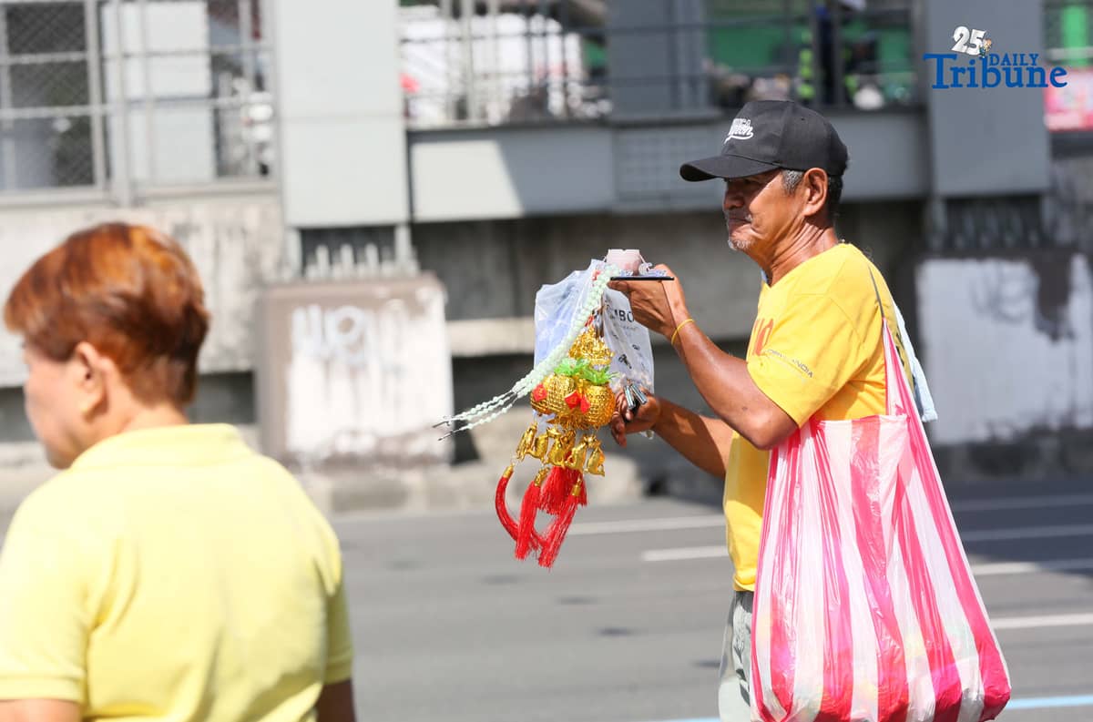 (December 27 2025)  A senior citizen begging the motorist to buy his rosary and lucky charm along Commonwealth avenue in Quezon City on Saturday December 27 2025. Photo/Analy Labor