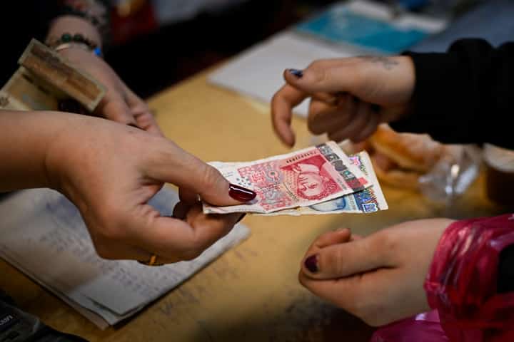A GROCERY store owner returns lev banknotes to a customer in a grocery store in the village of Chuprene, northwestern Bulgaria on 7 December 2025.