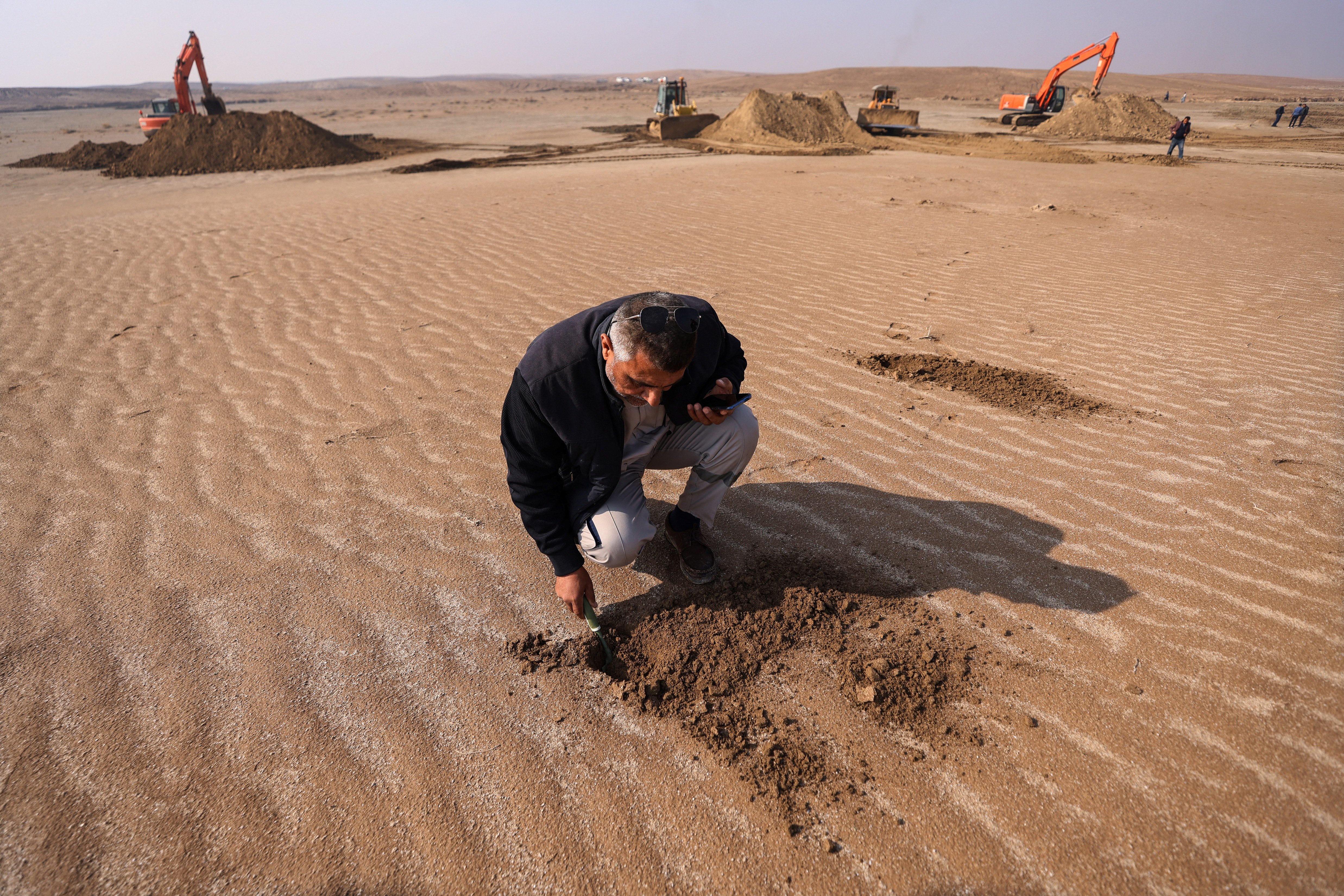 Iraqis cover soil with clay to curb sandstorms