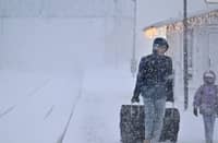 A WOMAN and child make their way with their luggage at the train station in Are as storm Johannes moves in over northern Sweden causing cancelled departures. (AFP)