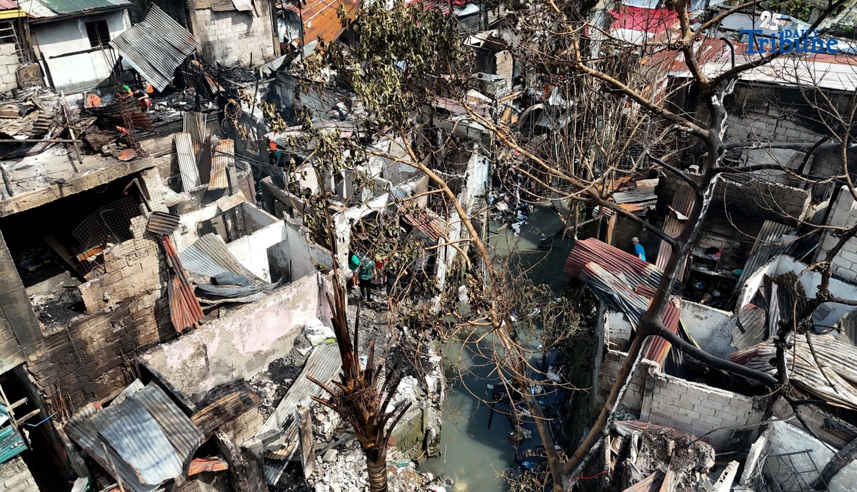 Residents affected by a fifth-alarm fire at Riverside Extension, San Roque Street, Barangay Commonwealth, Quezon City were seen on Monday, December 29, 2025, salvaging reusable belongings from the ruins of their homes. The blaze, which broke out Sunday night, December 28, affected more than 50 houses and displaced around 100 families, or about 500 individuals.