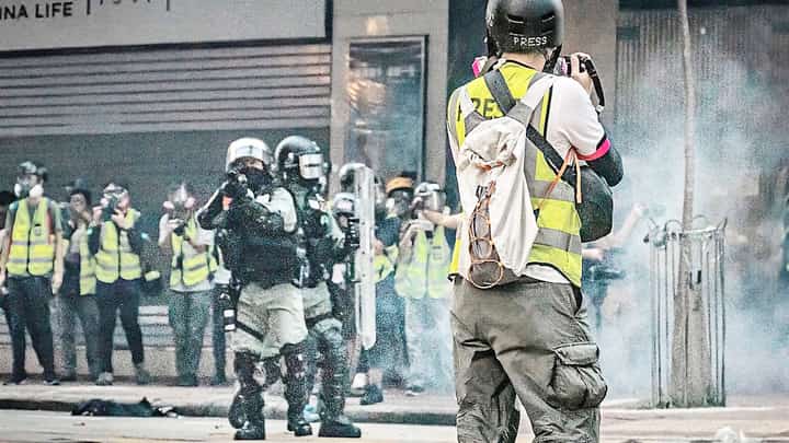 UNDER fire A photojournalist faces a wall of shields in Hong Kong.