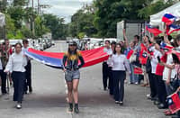 A COLOR guard composed of second-generation Taiwanese business members carries the ROC flag, symbolizing heritage, continuity, and community unity.