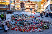 SWITZERLAND-ACCIDENT-FIRE
A mourner lays a flower bouquet at a makeshift memorial near the Constellation bar, on January 4, 2026, in Crans-Montana in honour of the victims of the fire that ripped through the venue in the luxury Alpine ski resort on New Year's Eve. Authorities investigating the New Year's blaze in the Swiss resort of Crans-Montana have identified 24 of the 40 people killed, including 11 minors and six foreign nationals, police said on January 4, 2026. Also 119 were injured during the fire, most of them seriously, according to the latest toll.