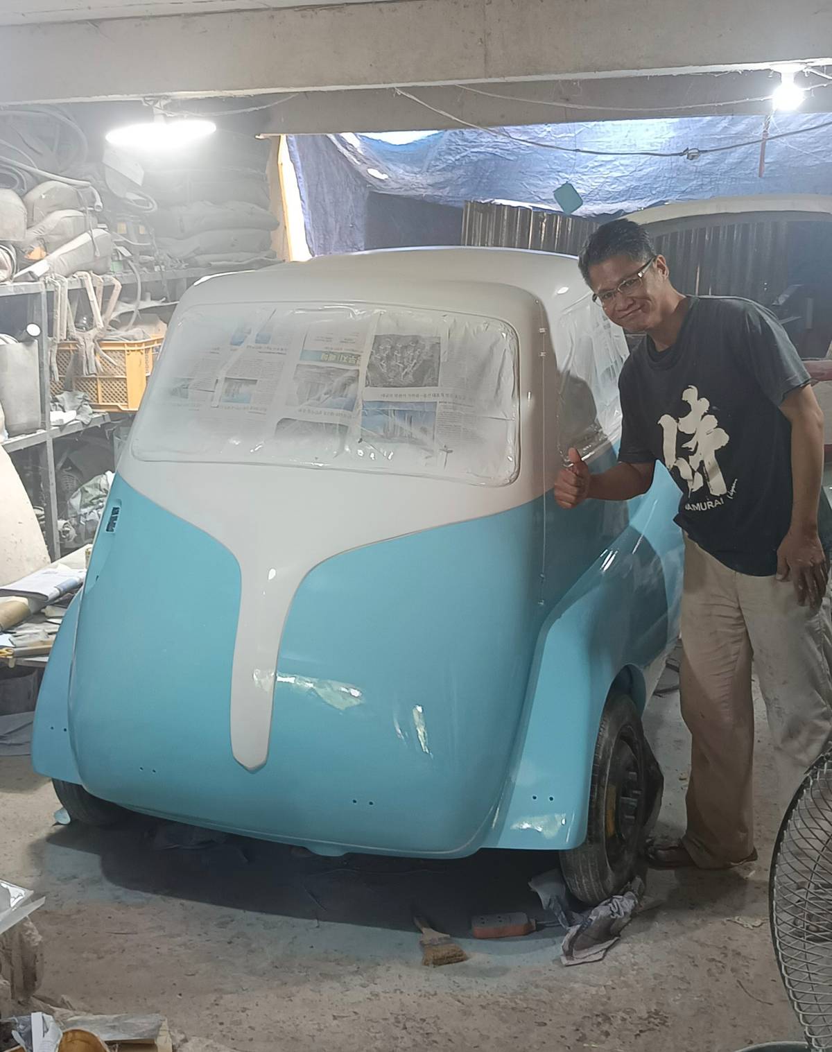 INSIDE a small workshop, a freshly painted body shell stands as part of the hands-on process behind building locally designed electric vehicles from the ground up.