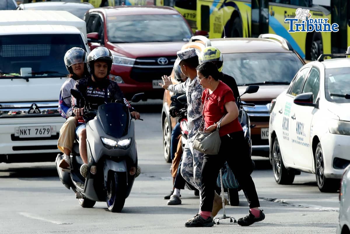 (January 05 2026) A Coast Guard personnel seen helping the PWD a passenger from a carousel bus crossing Edsa on Monday January 5 2026. Photo/Analy Labor