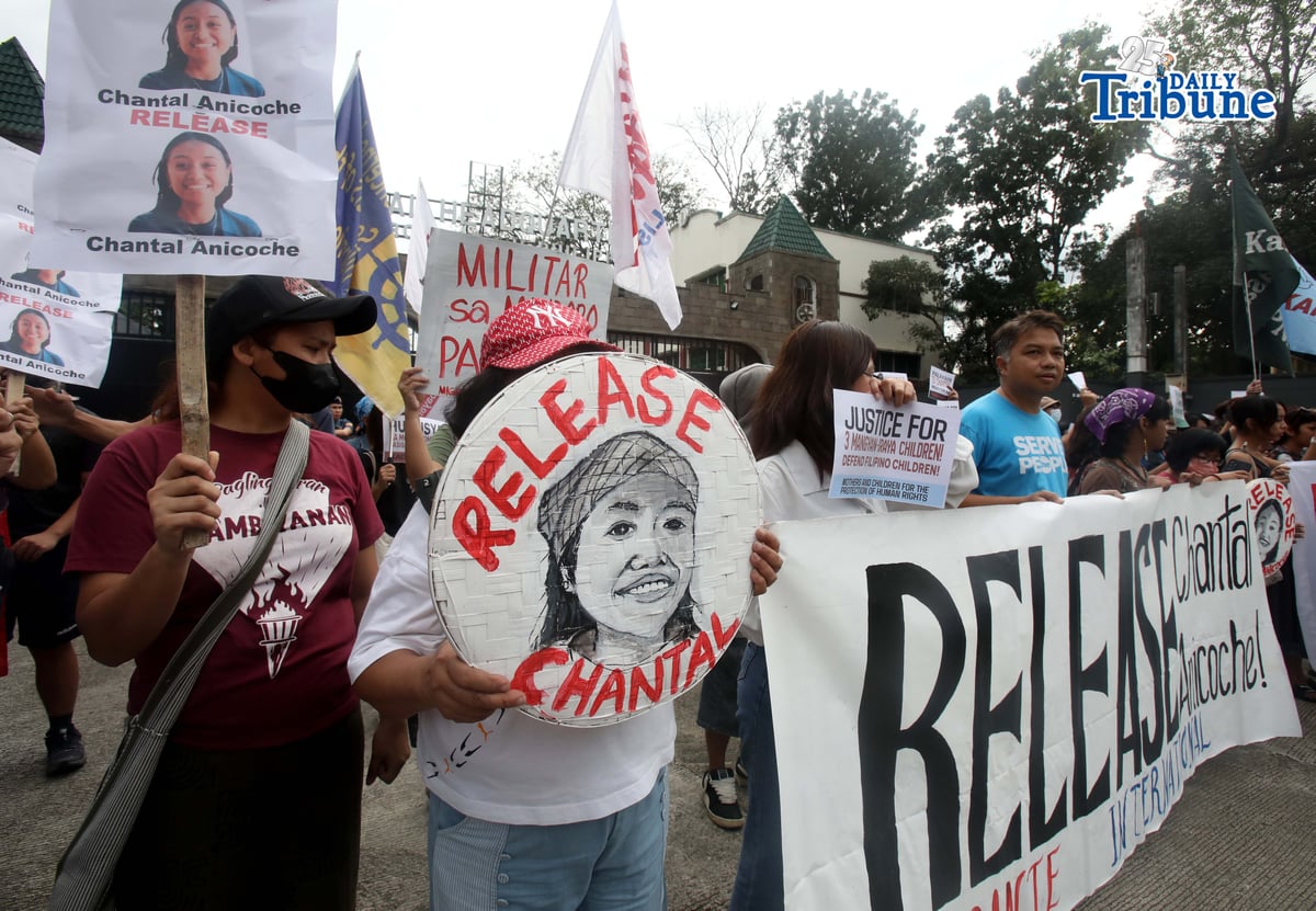 Human rights and migrant rights groups hold a protest outside Camp Aguinaldo in Quezon City on Monday, calling for the immediate release of Filipino-American activist Chantal Anicoche and condemning what they describe as her illegal detention following a reported encounter between government troops and the New People’s Army in Abra de Ilog, Occidental Mindoro, on 1 January.