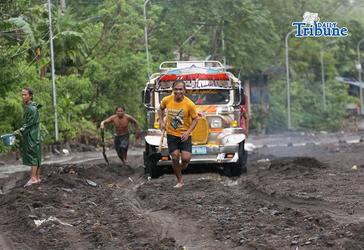 (January 17 2026) To help motorists passing through at the road in Brgy Masarawag, Guinobatan Albay, on Saturday January 17 2026, residents removed the sand and rocks scattered along the road because of flooding due to Tropical storm Ada on Saturday January 17 2026. Photo/Analy Labor