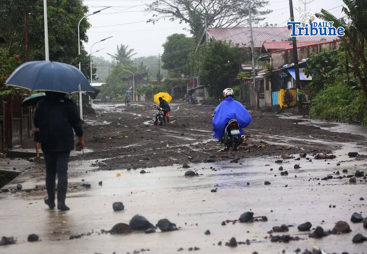 (January 17 2026) To help motorists passing through at the road in Brgy Masarawag, Guinobatan Albay, on Saturday January 17 2026, residents removed the sand and rocks scattered along the road because of flooding due to Tropical storm Ada on Saturday January 17 2026. Photo/Analy Labor