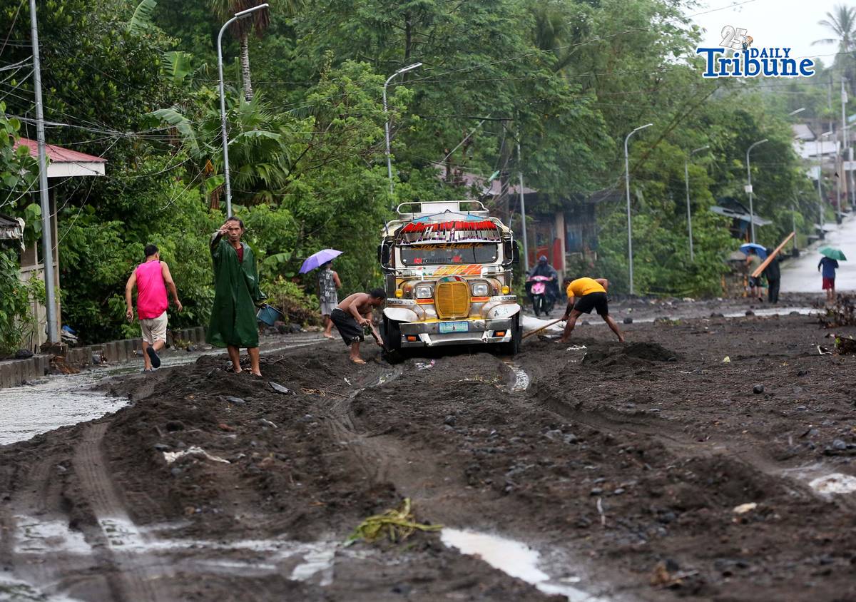 (January 17 2026) To help motorists passing through at the road in Brgy Masarawag, Guinobatan Albay, on Saturday January 17 2026, residents removed the sand and rocks scattered along the road because of flooding due to Tropical storm Ada on Saturday January 17 2026. Photo/Analy Labor