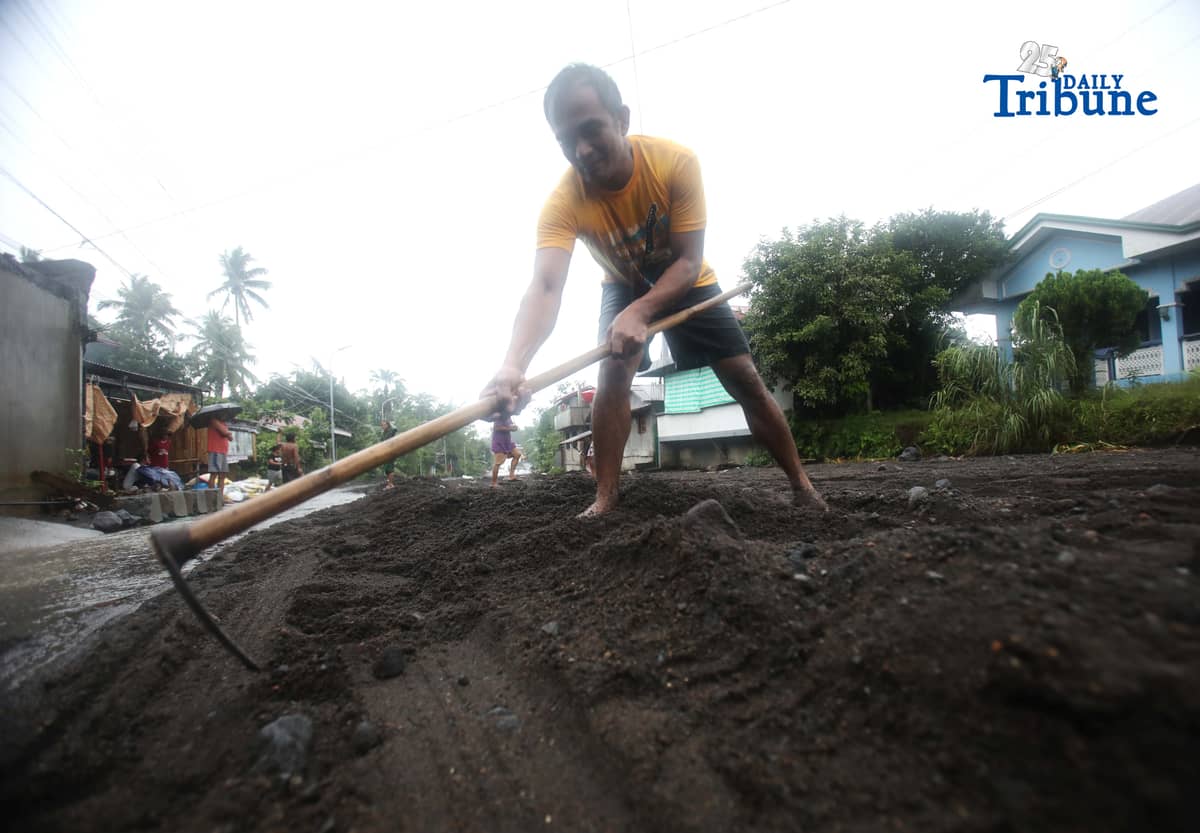(January 17 2026) To help motorists passing through at the road in Brgy Masarawag, Guinobatan Albay, on Saturday January 17 2026, residents removed the sand and rocks scattered along the road because of flooding due to Tropical storm Ada on Saturday January 17 2026. Photo/Analy Labor