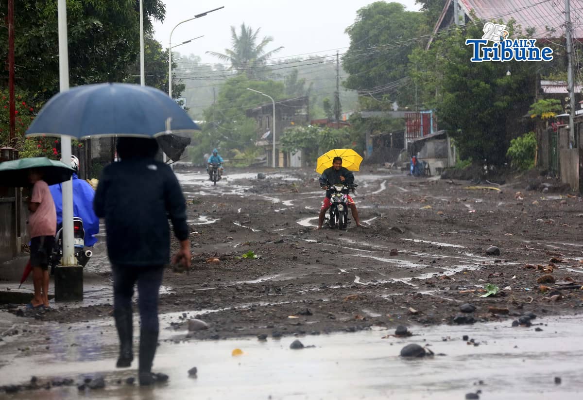 (January 17 2026) To help motorists passing through at the road in Brgy Masarawag, Guinobatan Albay, on Saturday January 17 2026, residents removed the sand and rocks scattered along the road because of flooding due to Tropical storm Ada on Saturday January 17 2026. Photo/Analy Labor