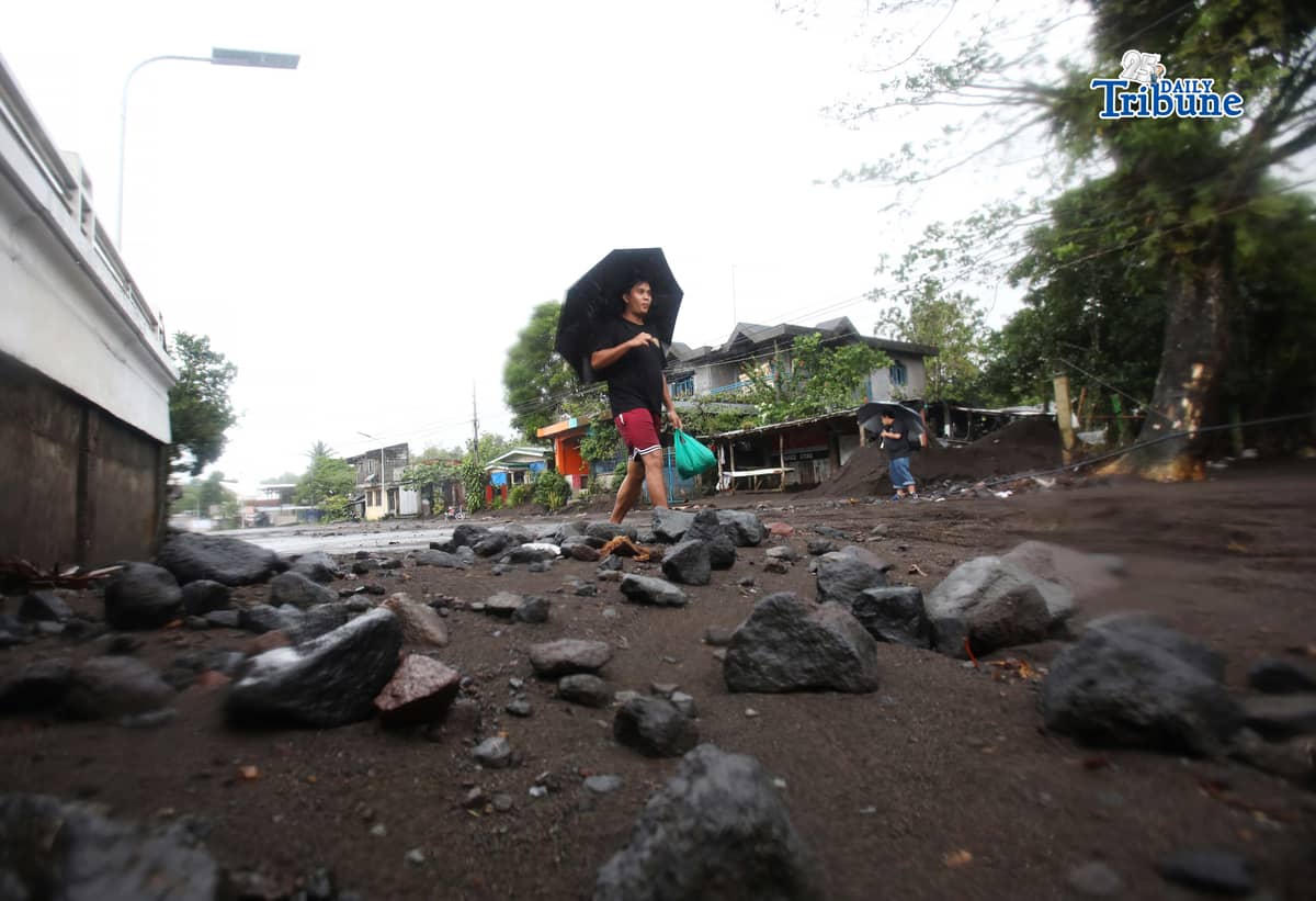 (January 17 2026) To help motorists passing through at the road in Brgy Masarawag, Guinobatan Albay, on Saturday January 17 2026, residents removed the sand and rocks scattered along the road because of flooding due to Tropical storm Ada on Saturday January 17 2026. Photo/Analy Labor