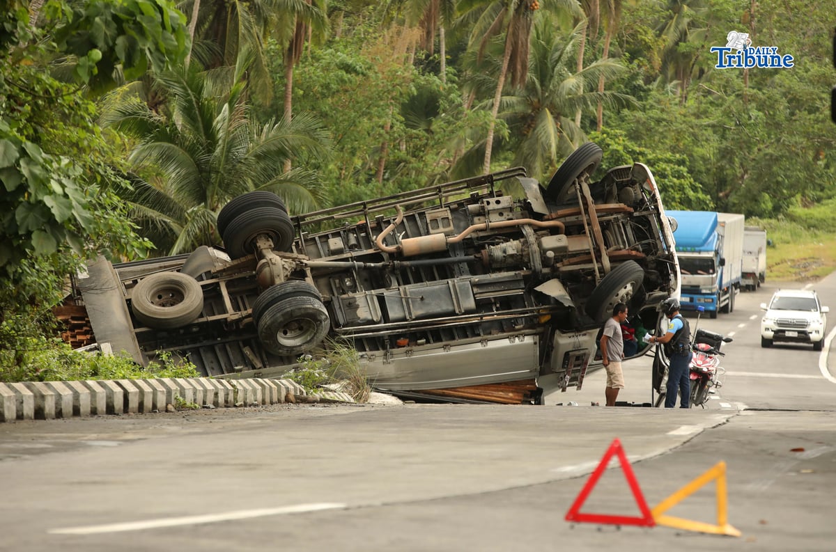 A six-wheeler truck loaded with coconut lumber overturned along the Gumaca bypass road in Quezon on Tuesday. Bystanders said the vehicle lost balance due to the wet and slippery road conditions.