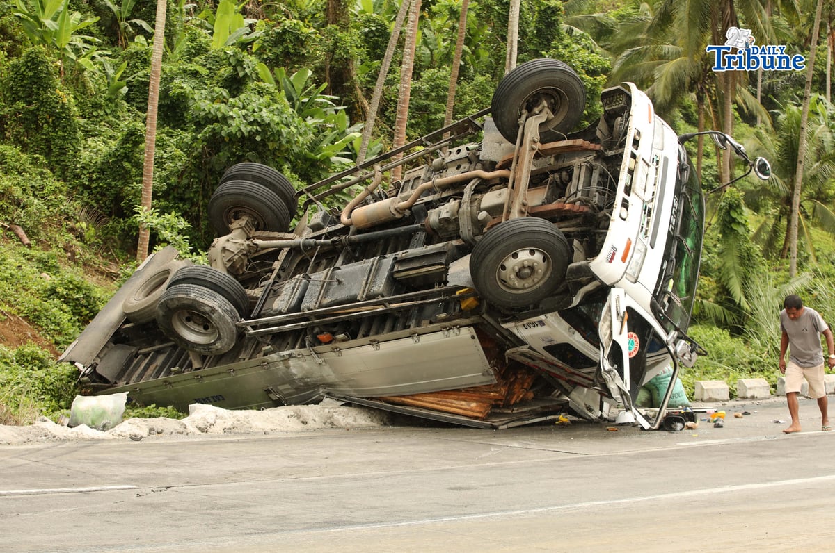 A six-wheeler truck loaded with coconut lumber overturned along the Gumaca bypass road in Quezon on Tuesday. Bystanders said the vehicle lost balance due to the wet and slippery road conditions.
