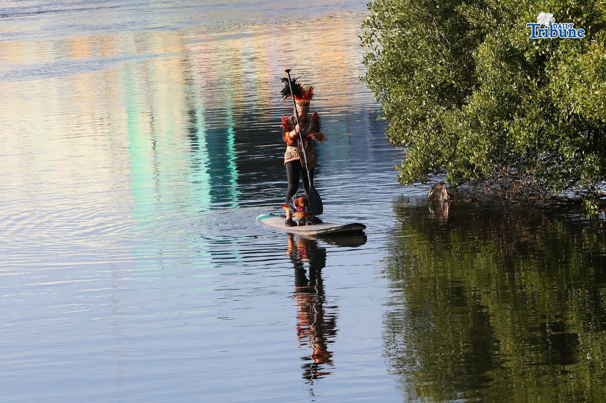Dinagyang warrior and dog paddle Iloilo River on festival eve