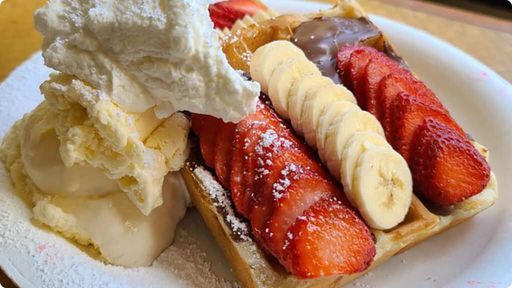 THE Aussie in Paradise (waffles, ice cream, Nutella, fresh strawberries, banana, powdered sugar, and whipped cream).