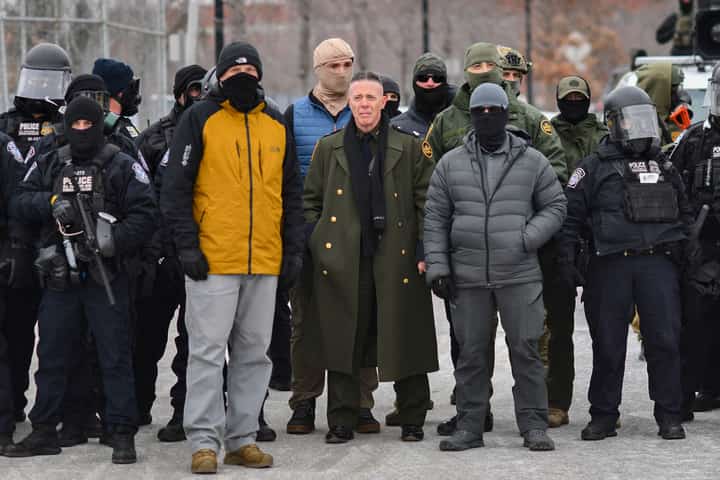 (FILES) US Customs and Border Protection Commander Gregory Bovino (C) stands flanked by fellow federal agents during a protest against ICE outside the Bishop Whipple Federal Building in Minneapolis, Minnesota, on January 15, 2026. The Department of Homeland Security denied a report on January 26 that US Border Patrol commander Gregory Bovino had been removed from his post, despite President Donald Trump reassessing harsh immigration crackdown tactics that led to the deaths of two Americans in Minneapolis. "Chief Gregory Bovino has NOT been relieved of his duties," DHS assistant secretary Tricia McLaughlin posted on X, reiterating the White House messaging that Bovino "is a key part of the President's team and a great American."