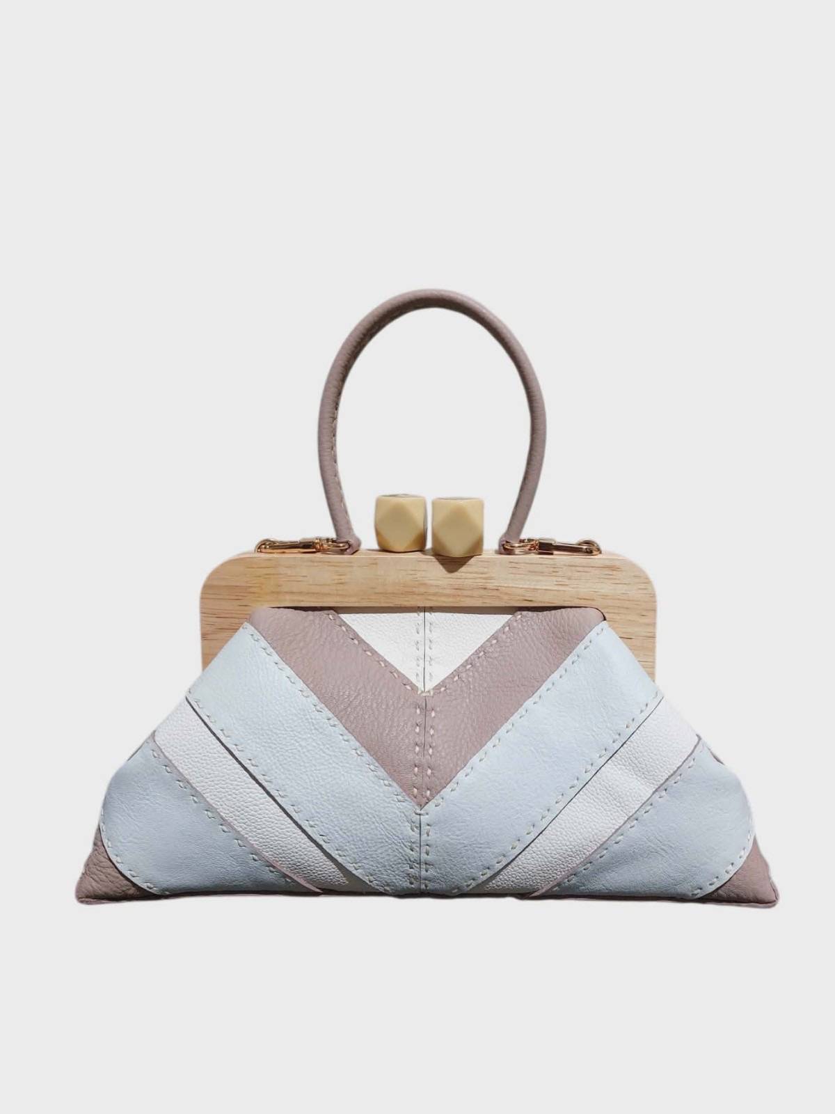 BESO Beso Bag by CHRISTIAN CERA. Hand-stitched chevron patchwork in cowhide leather in white and taupe. Top frame closure is made out of pinewood with polyhedron plastic kiss lock. Dimensions: 11” x 5.5” x 4”.