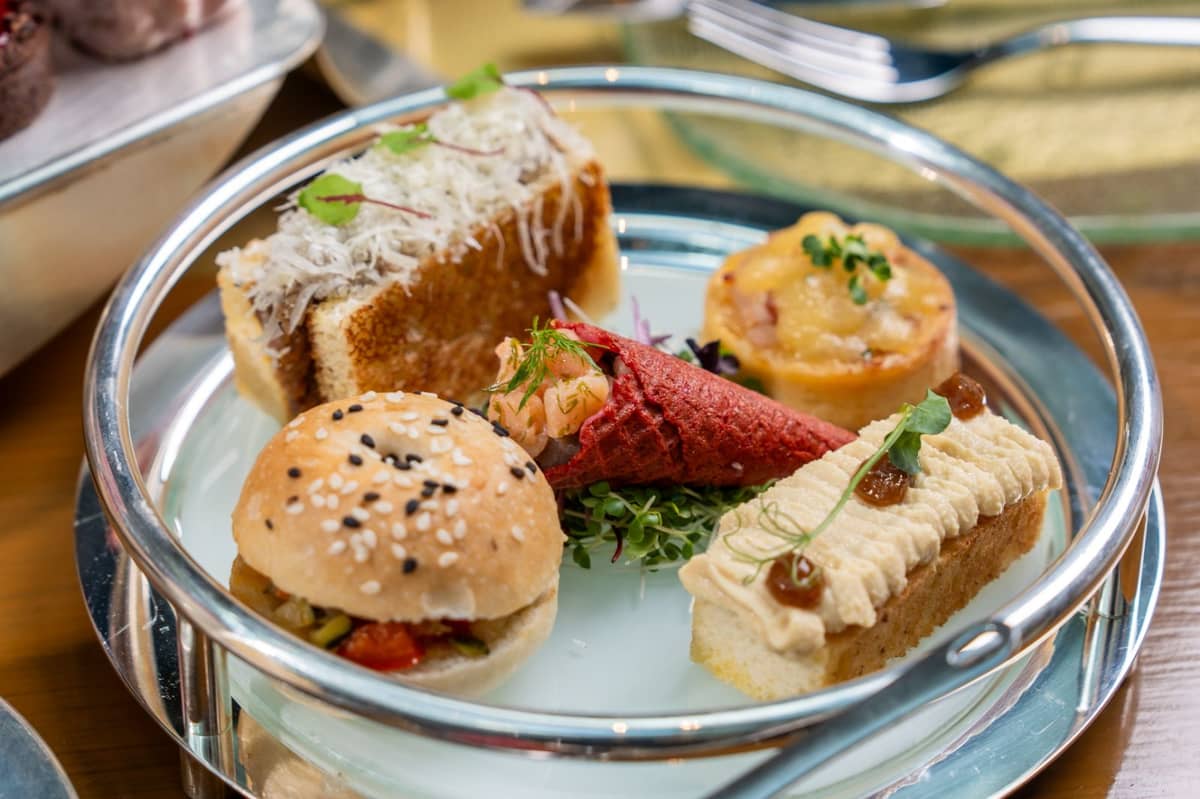 Savory bites include smoked salmon tartare in beetroot cone, foie gras brioche, mini quiche lorraine, roast beef with dijon and shimeji, and grilled vegetable and avocado bagel.