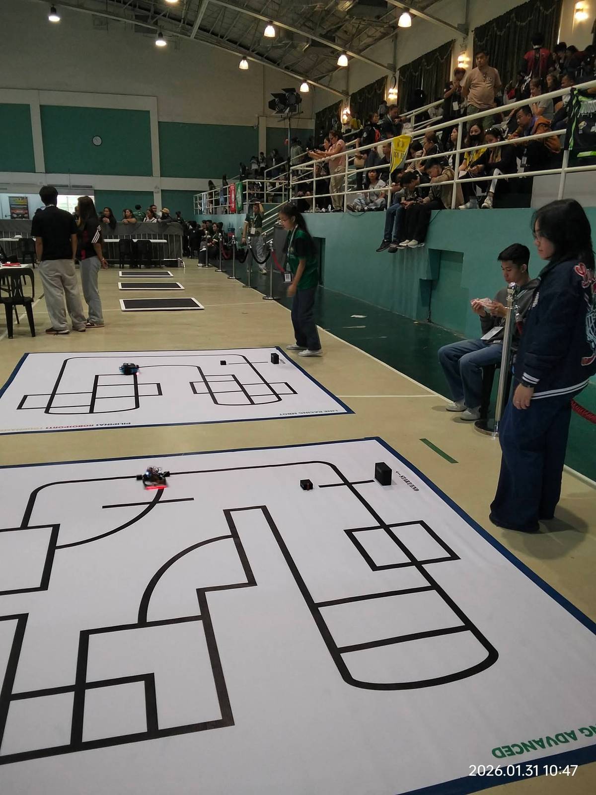 Students take their robots for a test-run on the Line Racing mazes before the competition starts.