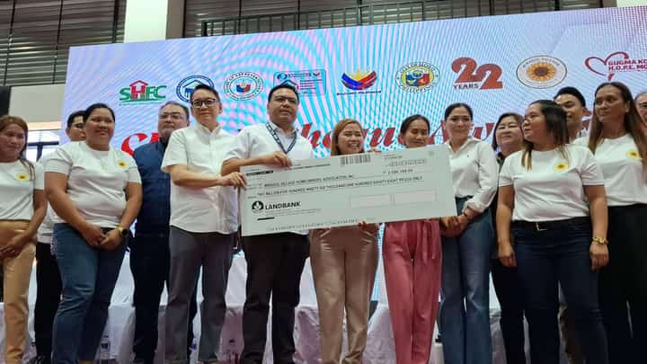 SOCIAL Housing Finance Corporation president and CEO Federico Laxa (left) and Department of Human Settlements and Urban Development Secretary Jose Ramon Aliling hand a mock check worth P2.6 million to Mirasol Village Homeowners’ Association president April Rose Segumalian and another co-officer.