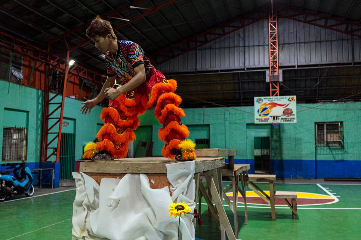 Jhayvee Sicat memorizes his dance steps atop a wooden platform as his crew, the Philippine Rui Dragon Dance group, prepare for an upcoming lion dance competition.