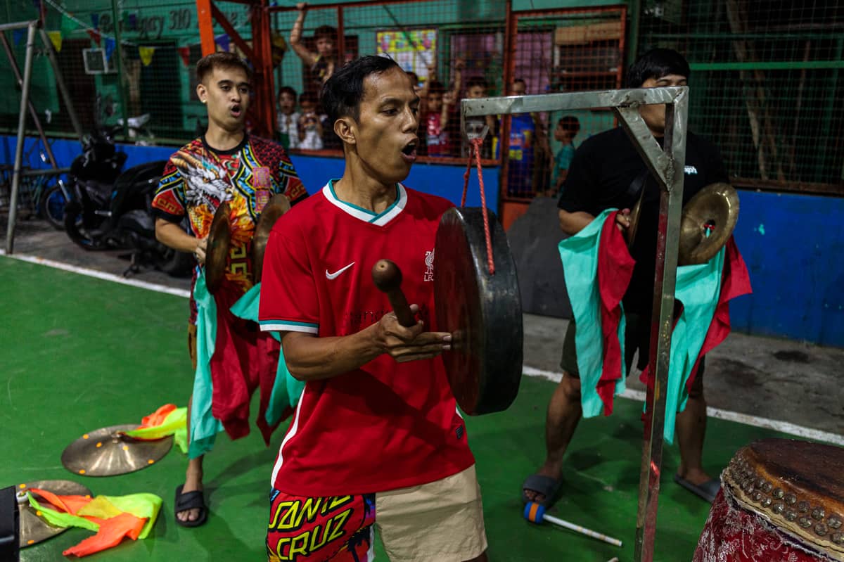 Drummers shout in unison as they pound out rhythms during a practice at a basketball court in downtown Manila on Friday, 6 February 2026.