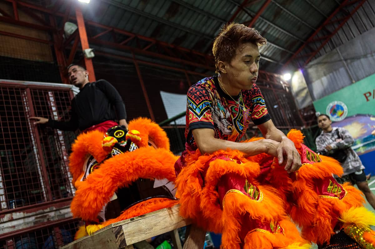 Jhayvee Sicat and Noah King catch their breath after a practice session at a basketball court in Manila on Friday, 6 February 2026, a week before they defend their Lion Dance competition title.