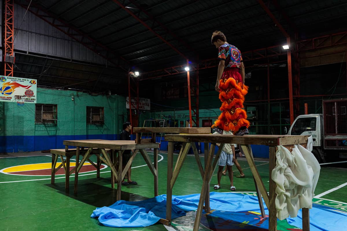 Jhayvee Sicat walks along the wooden platform as he internalizes his dance steps during a practice inside a basketball court in Manila on Friday, 6 February 2026. Sicat says his troupe typically spends two to three months preparing for the country’s biggest and only lion and dragon dance competition in the country.