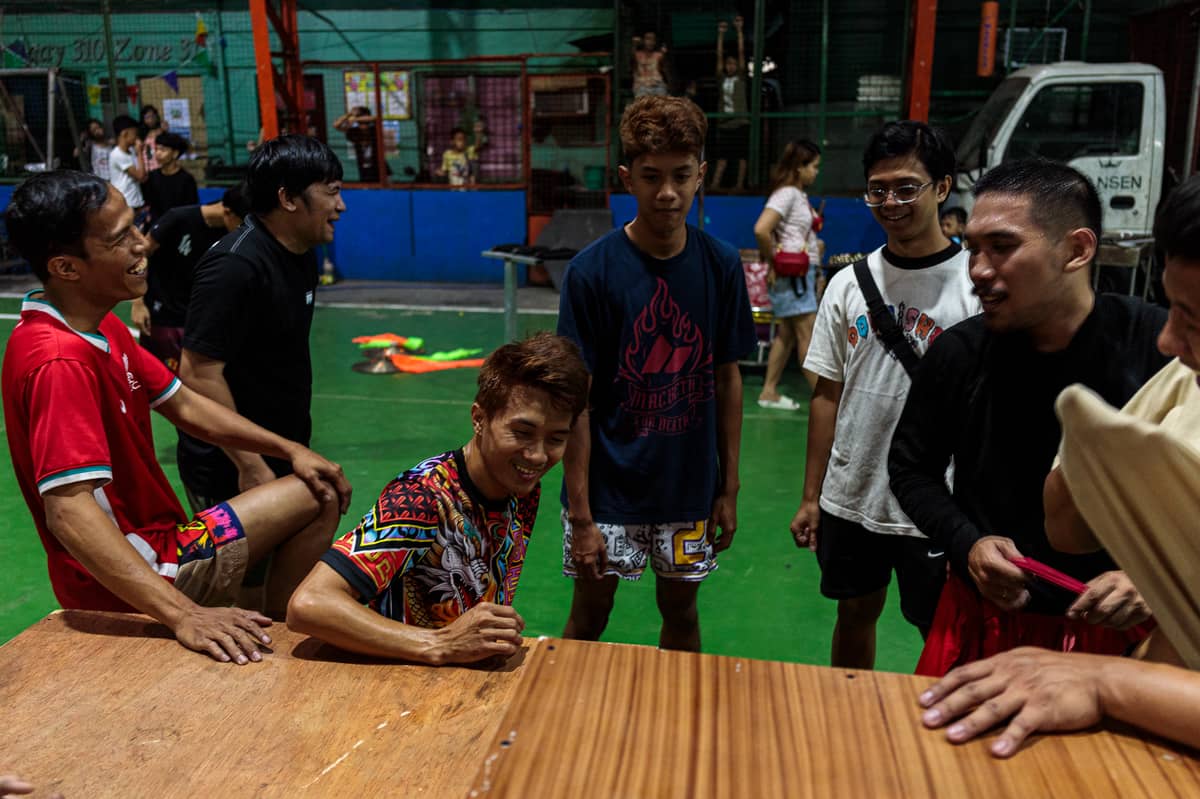Jhayvee Sicat and his crew, the Philippine Rui Dragon Dance group, share a laugh as they discuss their practice at a basketball court in Manila on Friday, 6 February 2026.
