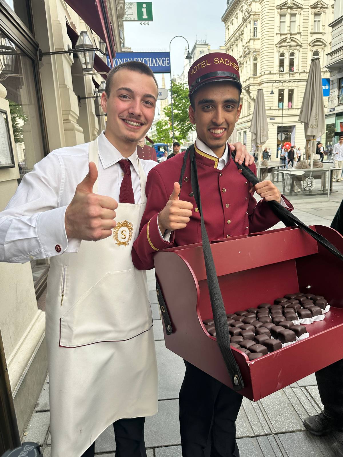SERVERS handing out sacher torte squares outside Hotel Sacher.