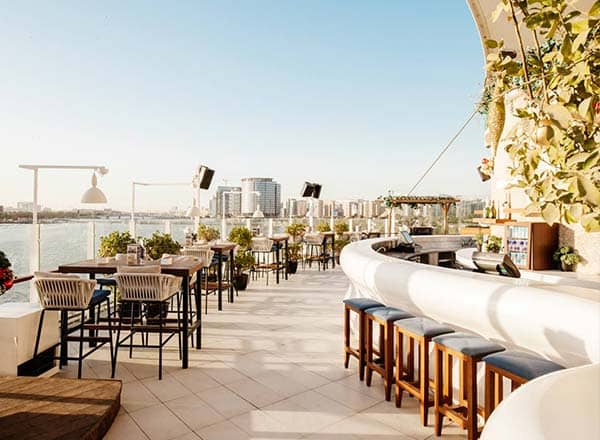 Sky social scene on Level 81 — the rooftop lounge and terrace offer dramatic views with signature city lights after dusk.