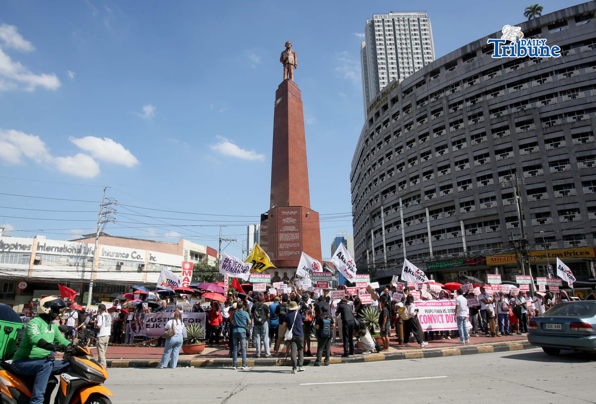 Members of Akbayan Partylist, Simbahan at Komunidad Laban sa Katiwalian (SIKLAB), and families of EJK victims gather at Boy Scout Circle in Quezon City on Monday, 23 February 2026, holding placards demanding justice and full accountability amid the International Criminal Court’s confirmation of charges hearing against former President Rodrigo Duterte over alleged crimes against humanity linked to the government’s anti-drug campaign.