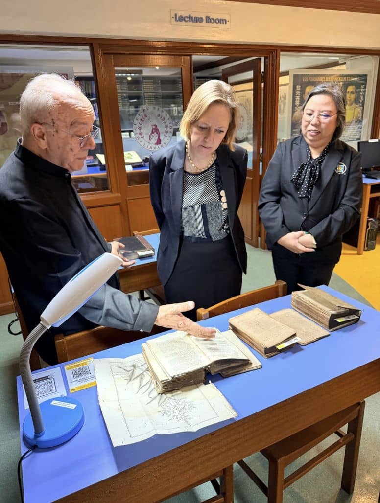 UST Prefect of Libraries Fr. Angel Aparicio, O.P. (left), and Miguel de Benavides Library Chief Librarian Ma. Cecilia Lobo (right) present rare archival items from the Antonio Vivencio del Rosario UST Heritage Library to Sweden Ambassador Anna Ferry during her visit to the campus.