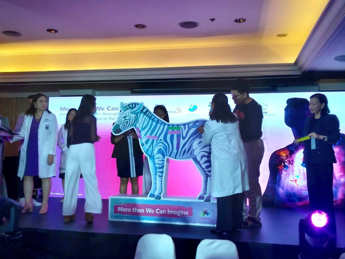 Panelists pin their ribbons of commitment on a zebra cutout, the symbol of rare disease awareness.