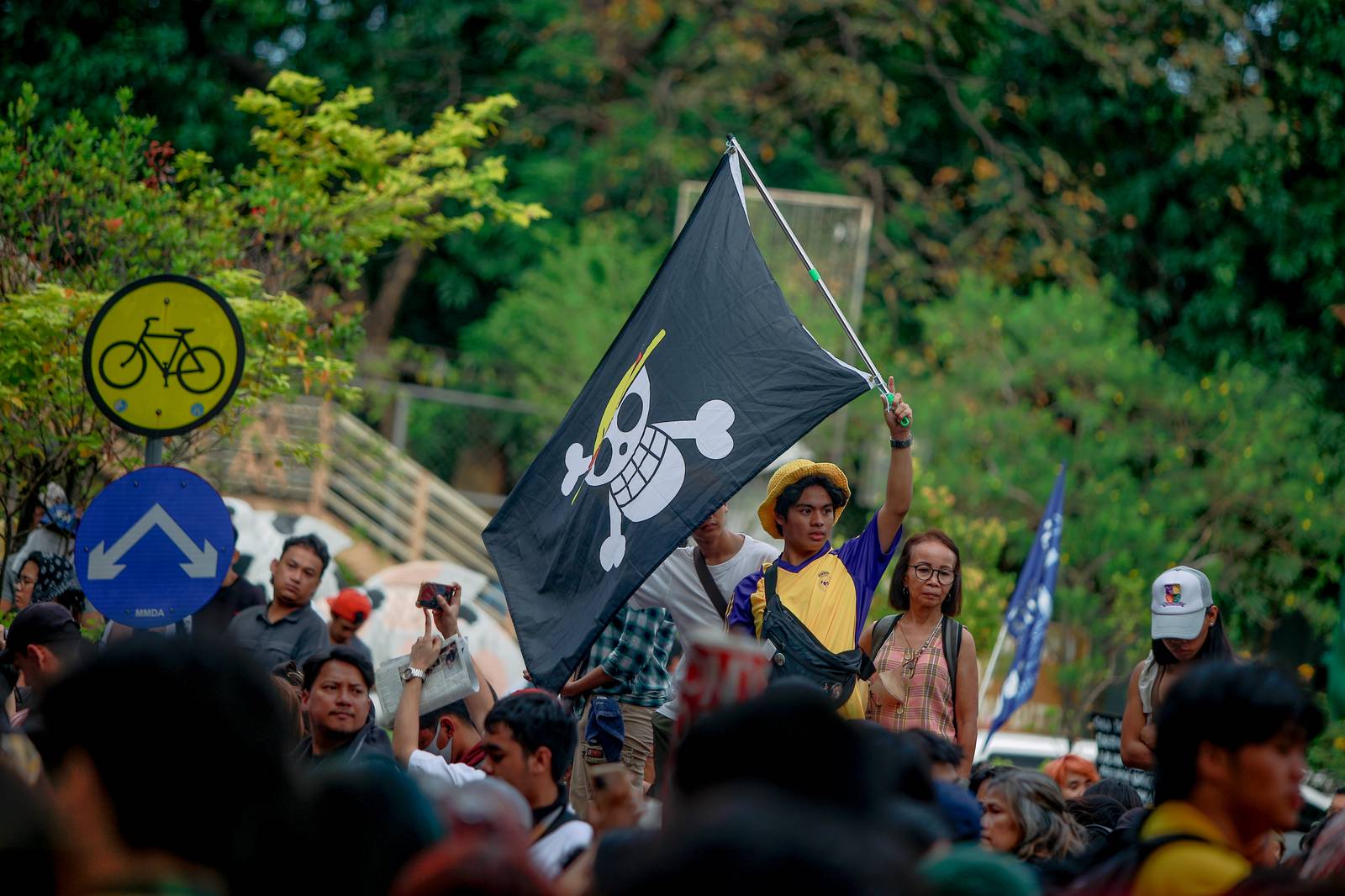 A man who cosplays as Monkey D. Luffy from the animated show "One Piece" raises a flag of the Straw Hat Pirate Crew. Globally, the flag has been recognized as a symbol of defiance, resistance, and solidarity against corruption and authoritarianism for Gen Z protesters in Asia, especially in the Philippines, Indonesia, and Nepal. Aram Lascano
