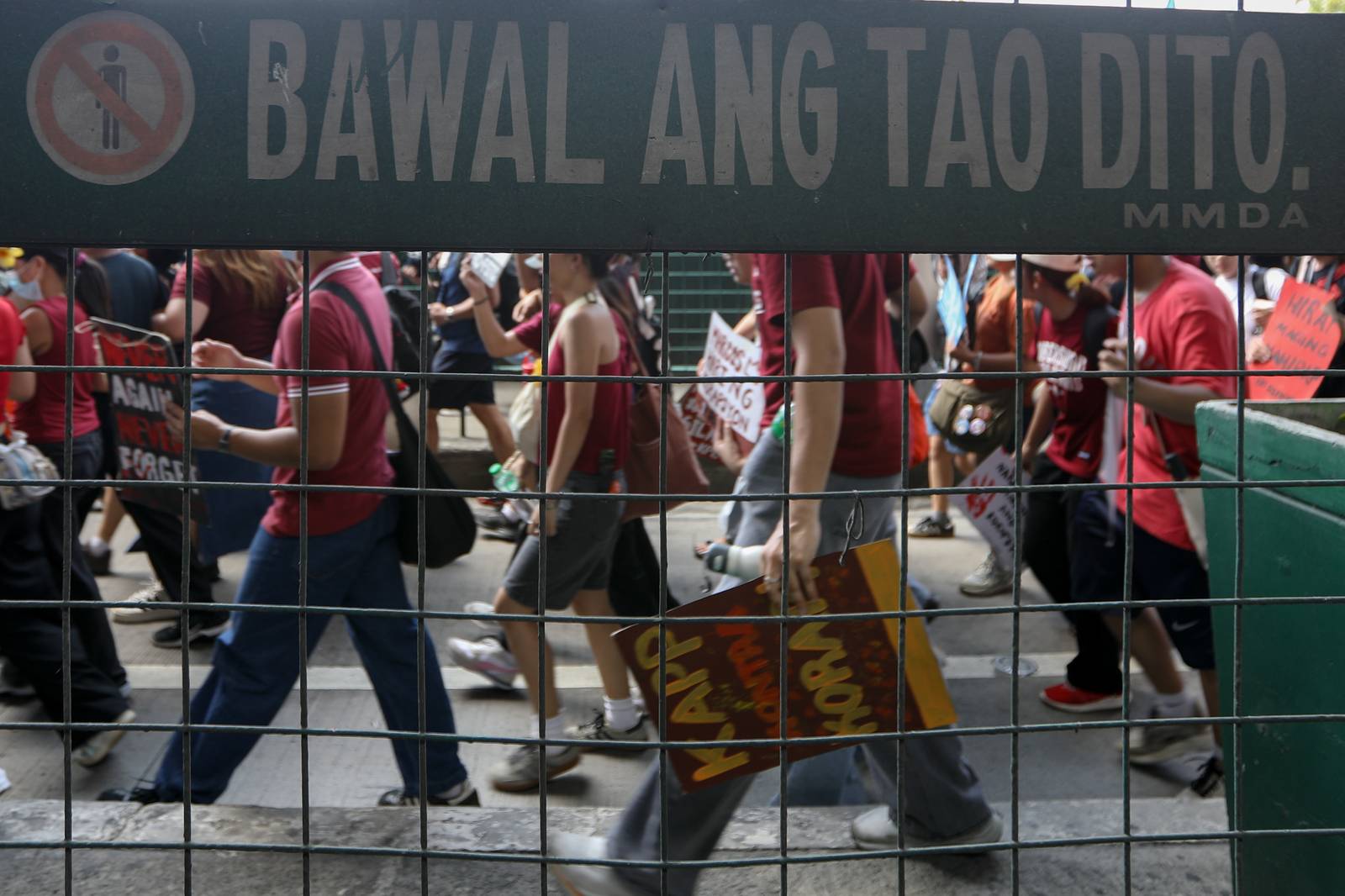 A sign that says "People are not allowed here" is seen to contrast the protesters walking after breaking through shielded police that prohibited them to stage a program due to lack of permit.
