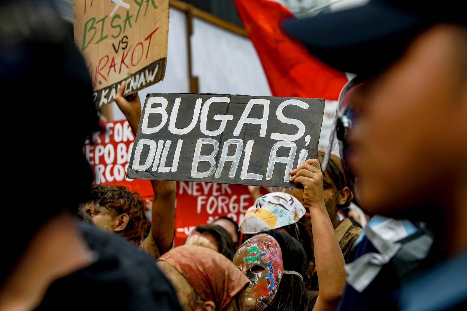 A card saying "rice not bullets" is raised at a protest in EDSA. Aram Lascano